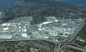 Aerial view of San Diego's Midway District showing highways, commercial buildings, parking lots, and coastal waterways.